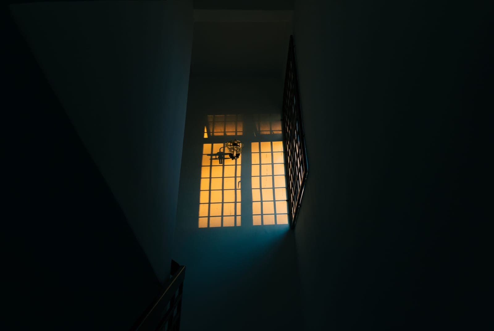 A quiet domestic hallway at night, the kind of space a working smoke alarm protects