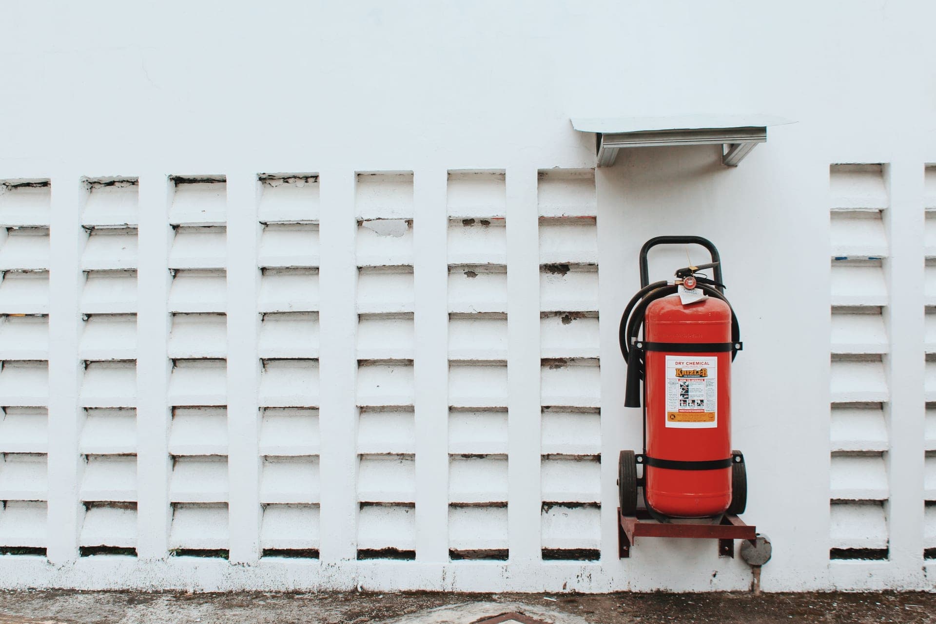 Red ABC fire extinguisher mounted on a bracket beside a kitchen doorway