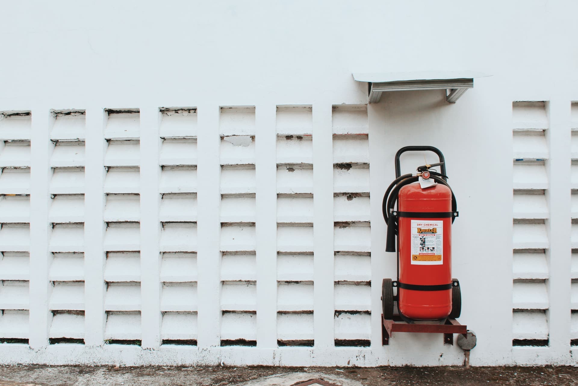 Illustrative photo of a red ABC dry chemical fire extinguisher mounted on a wall bracket