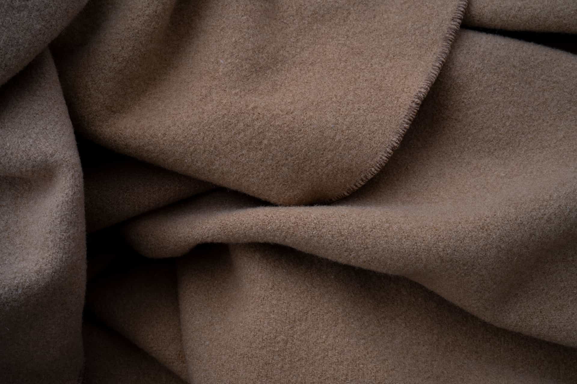 Illustrative photo of a folded fire blanket in its wall pouch beside a kitchen range