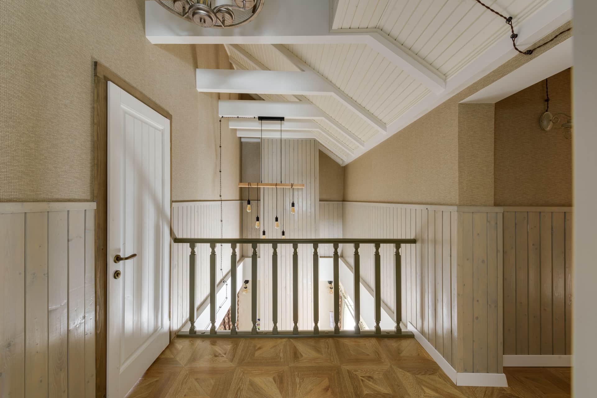 Upstairs hallway ceiling with a hardwired smoke alarm between bedroom doorways