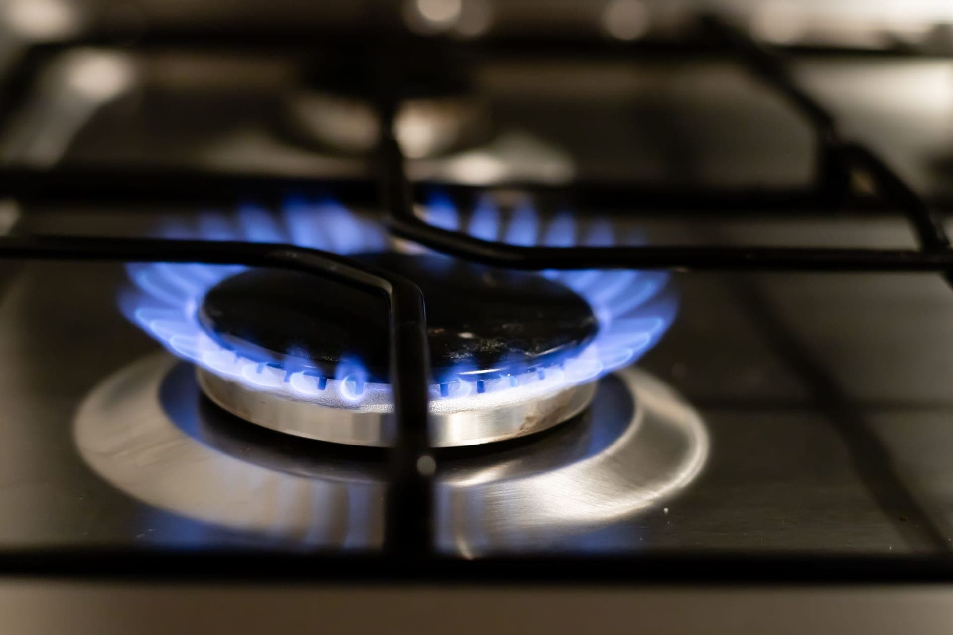 Gas hob with a burner lit in a domestic kitchen